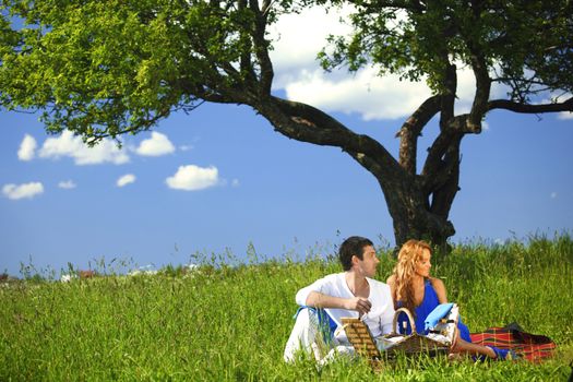 man and woman on picnic in green grass