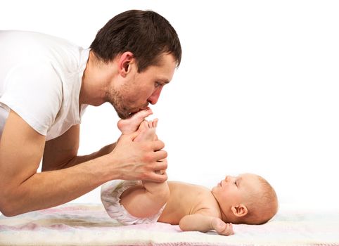 Young caucasian father kissing feet of his baby son