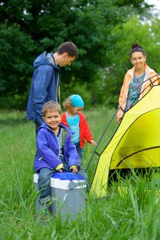 Young boy with his family near tent in camping on the nature