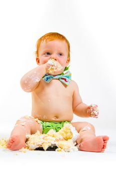 A baby boy gets to eat cake for the first time on his first birthday in this cake smash in studio against a white background.