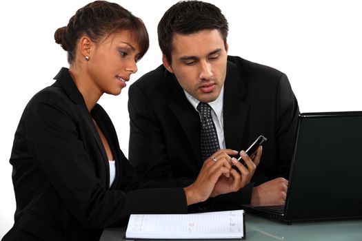 Businesspeople looking at a mobile phone