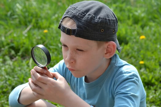 the teenager observes through magnifying glass