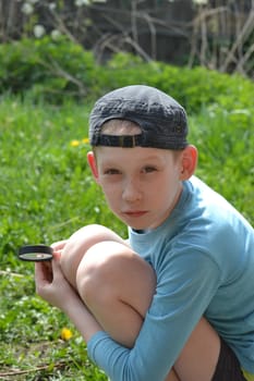 the teenager observes through magnifying glass