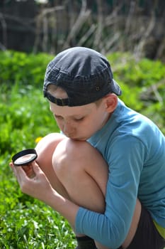 the teenager observes through magnifying glass