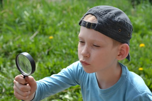 the teenager observes through magnifying glass