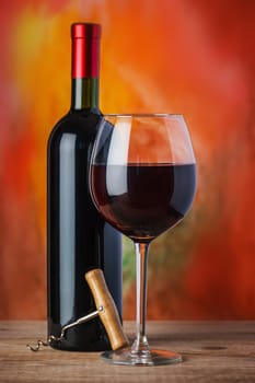 Wine, glass and the bottle on a colored background