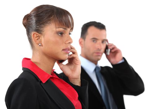 businesswoman and businessman talking on their cells