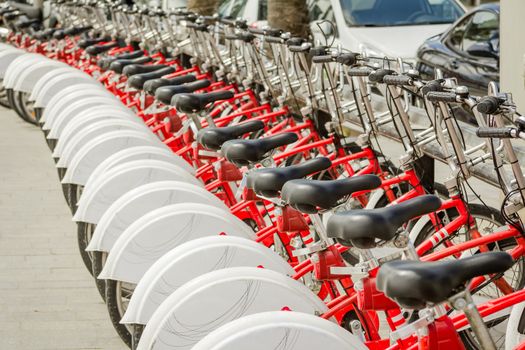 Red bicycles parked in a row on the street, in Barcelona, Spain