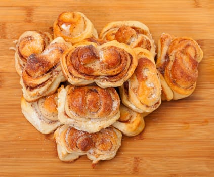 Fresh appetizing sweet rolls, on wooden board, top view