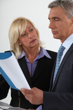 Senior business couple going over important document