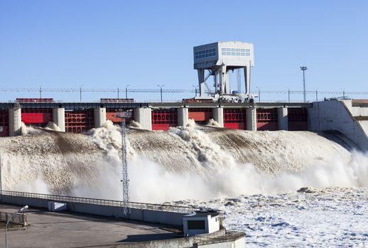 Spring flood water flowing on hydroelectric power station dam