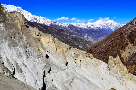 Mountain trekkers walking in the mountains with white peaks background, Himalayas, Nepal