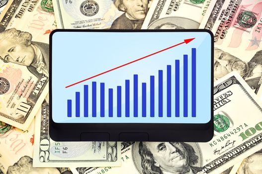 digital tablet with graph on background of dollars