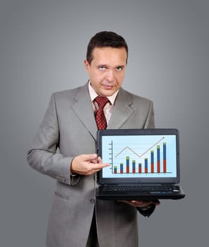 businessman with laptop in hand points to chart of profits