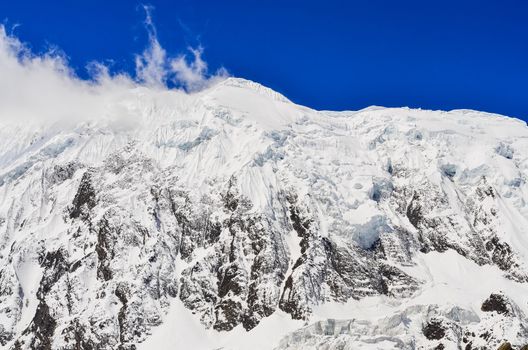 Snow mountain peak with glacier, clouds and blue sky, Himalayas, Nepal