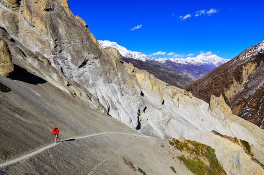 Trekker in red jacket walking in Himalayas mountains, Nepal