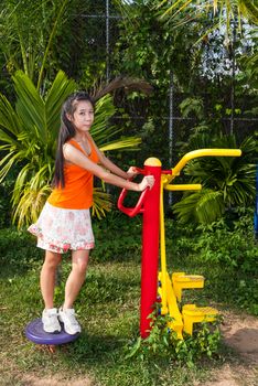 Asian Thai Girl with Exercise Machine in Public Park.