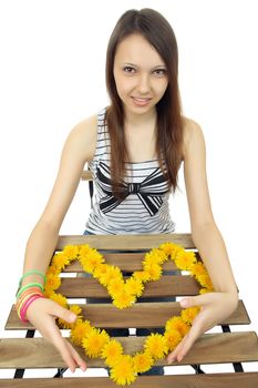 One Caucasian teen girl 16 years old, holds a heart of yellow dandelion flowers.  Young, beautiful girl holding a heart composed of yellow dandelion flowers. One person, Caucasian, female, teenager, vertical image, isolated on white background.