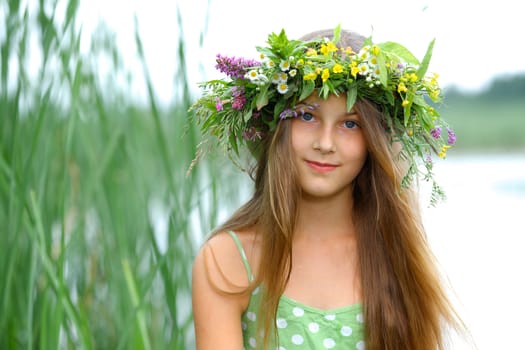 Clouse-up spring portrait beautiful girl with wreath of flowers
