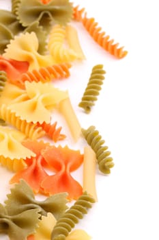A different pasta in three colors close-up are located right on the white background.
