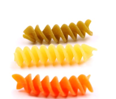 Close-up pasta eliche tricolori are located on the white background.