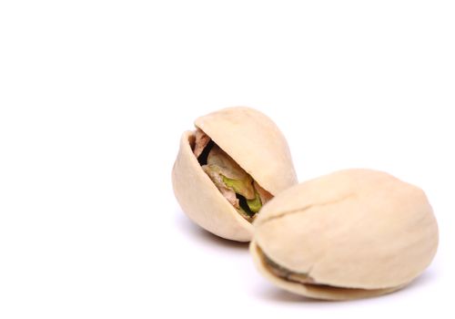Two toasted pistachio close-up on the white background