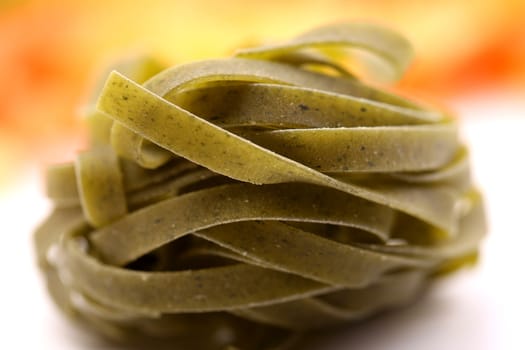 Tagliatelle paglia e fieno homemade tipycal italian pasta close-up on the white-yellow background.