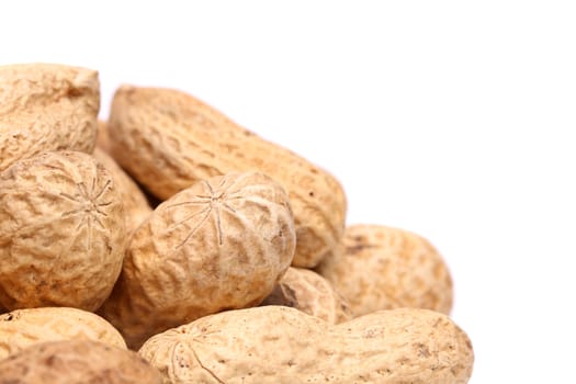 Frame close-up of some peanuts are located to the left.