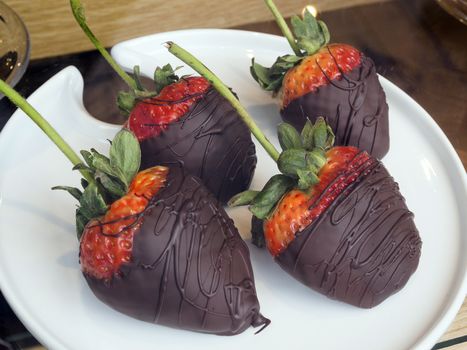 Chocolate covered strawberries in white plate