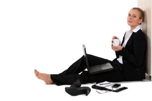 Barefoot businesswoman sat with coffee and laptop