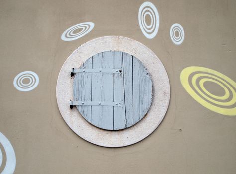 round wooden window on building facade