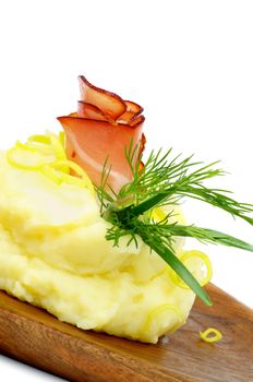 Snack of Rolled up Delicious Bacon with Mashed Potato, Dill, Spring Onion and Leek closeup on Wooden Plate