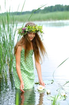Spring portrait beautiful girl with wreath of flowers. Vertical view