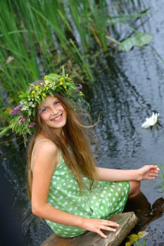 Spring portrait beautiful girl with wreath of flowers. Vertical view