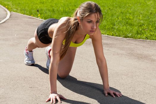 Beautiful young woman getting ready to run from lying pose