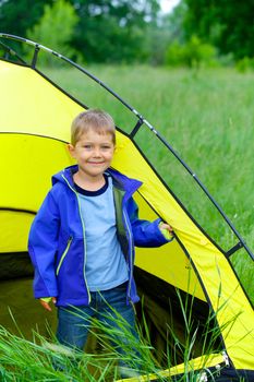Cute little boy camping with tent outdoor.