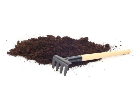 Rake and dirt isolated on white background, gardening concept