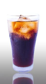 Glass filled with ice cubes and Cola soda over a white