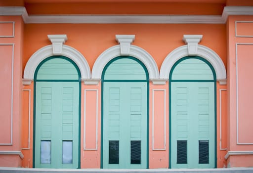 Green door on orange wall background