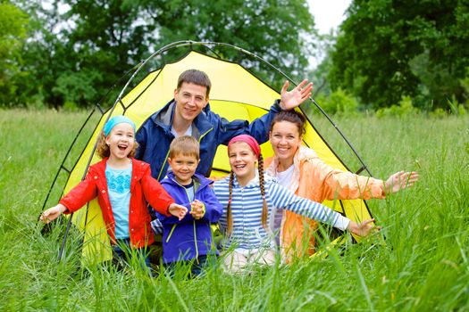 Family with three kids in tent in camping on the nature.