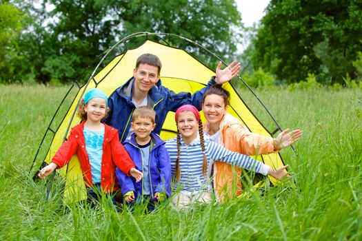 Family with three kids in tent in camping on the nature.