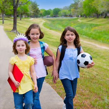 Children kid girls walking to schoool with sport balls folders and backpacks in outdoor park