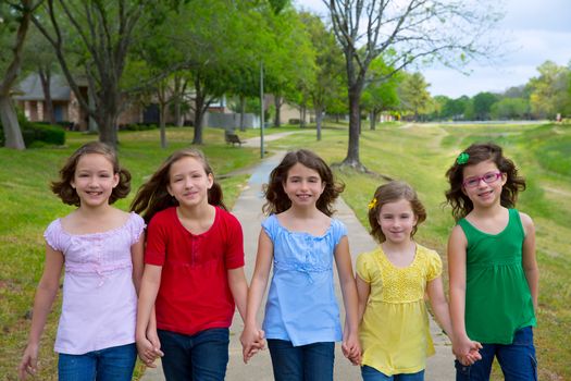 Children group of sisters girls and friends walking happy in the park outdoor