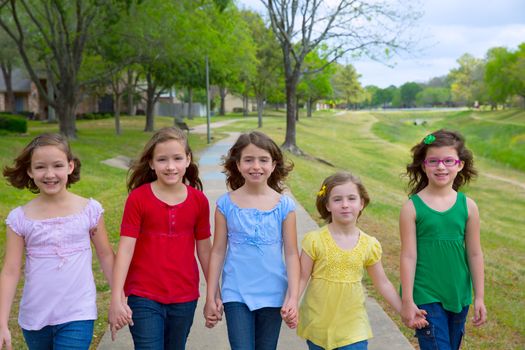 Children group of sisters girls and friends walking happy in the park outdoor