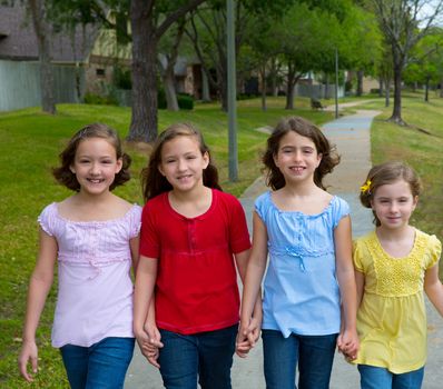 Children group of sisters girls and friends walking happy in the park outdoor