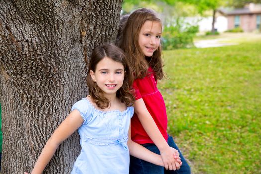 Children group friend girls friends playing on tree trunk at the park outdoor