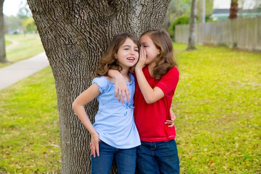 children kid friend girls whispering ear playing smiling in a park tree outdoor