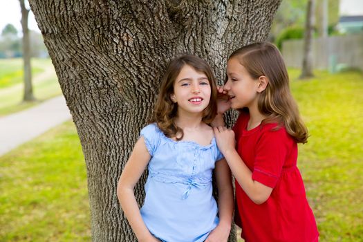 children kid friend girls whispering ear playing smiling in a park tree outdoor