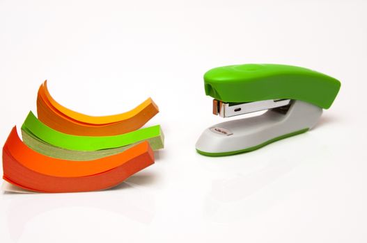 stapler with colored paper on a white background