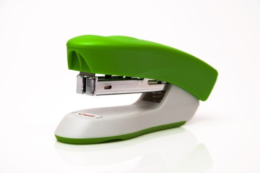 green stapler on a white background